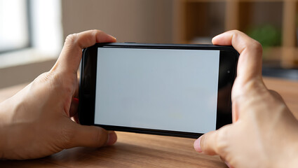 A persons hands hold a smartphone with a blank white screen
