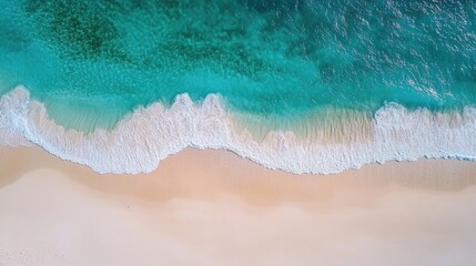 Aerial view of turquoise waves on a white sand beach.