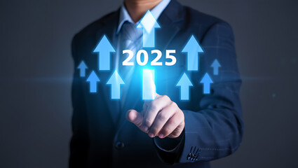A businessman touches a screen showing upward arrows and the year 2025