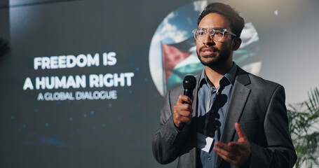 Man, speech and mic at conference event of conflict, freedom and human rights crisis. Person, public speaking and raise awareness for global oppression, stop injustice and action for Palestine peace