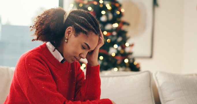Sad, sofa and woman in home on Christmas with crying for depression, loneliness or hopeless. Mental health, holidays and person with tears and emotions for alone on xmas in living room at apartment.