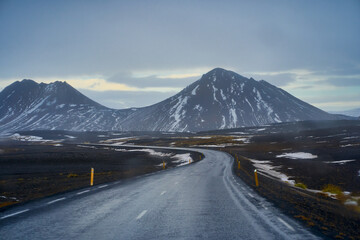 Road trip with empty road in iceland and big snow mountain view while driving a car.