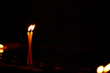 Row of burning candles in a dark church interior, creating a peaceful and spiritual atmosphere....