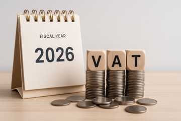An image of a calendar and blocks spelling "VAT" placed over stacks of coins, representing value-added tax in the fiscal year 2026