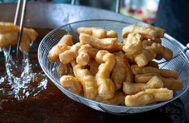 Close-up of aman making fried dough sticks