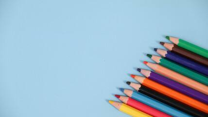 Various colored pencils isolated on blue background. copy space	