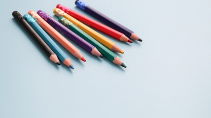 Various colored pencils isolated on blue background. copy space