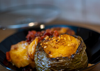 Photo shows a stuffed pepper and  with rice inside a cooking pan. Greek traditional food.