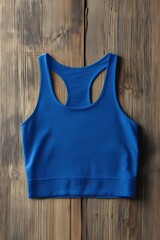 A vibrant blue sports bra mockup on a rustic wooden surface, showcasing its sleek design and fabric texture.