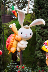 Cute and adorable cartoon-like rabbit and turtle emerging from flowers at gardens by the bay