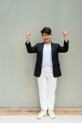 young man in a suit with arms raised