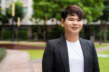 portrait of a young gay businessman in park