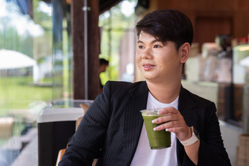 Young cute gay man makeup artist businessman in coffee shop restaurant wearing business clothes