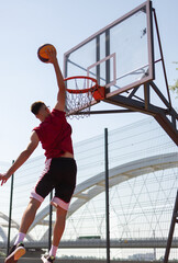 Sportmen playing game of basketball at outdoor court