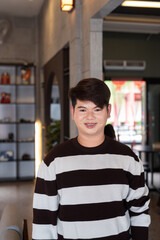 young happy gay man in cafe