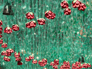 chain of arctificial red roses embedded in green plastic leaves hanging in the sky