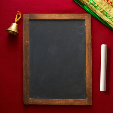 Traditional Indian Slate Chalkboard with Bell and Chalk on Red Background