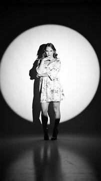 Fashion model showing how to pose, studio shot under the spotlight