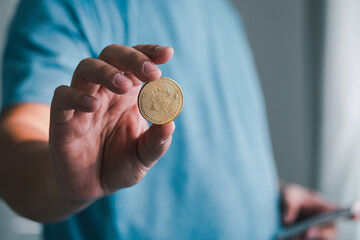 Hand holding a coin focus business setting close-up shot indoor environment financial concept