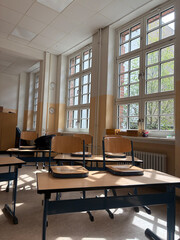 Sunlit Classroom with Wooden Desks and Chairs