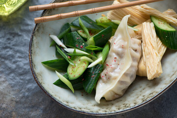Smashed cucumber salad with steamed pork dumpling and yuba, horizontal shot, closeup, selective focus