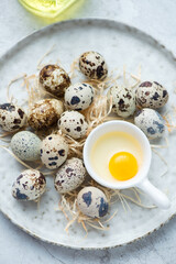 White plate with fresh uncooked quail eggs, vertical shot, middle closeup, selective focus