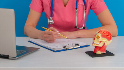 Anatomical model human head on work desk of doctor in medical clinic.