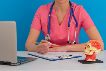 Anatomical model human head on work desk of doctor in medical clinic.