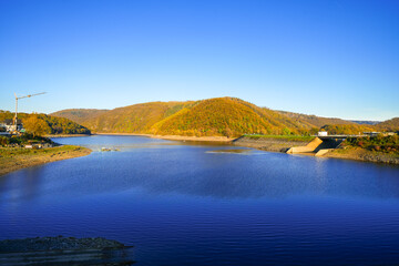 View of the autumn landscape at Eiserbachsee in Rurberg. Idyllic nature at the Eifel Rursee in the Volcanic Eifel region of Rhineland-Palatinate.
