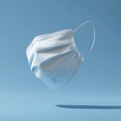 White Surgical Mask Floating on Light Blue Background