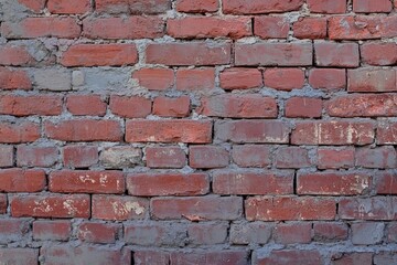 Old red brick wall texture with weathered surface and rough cement joints for construction and background use