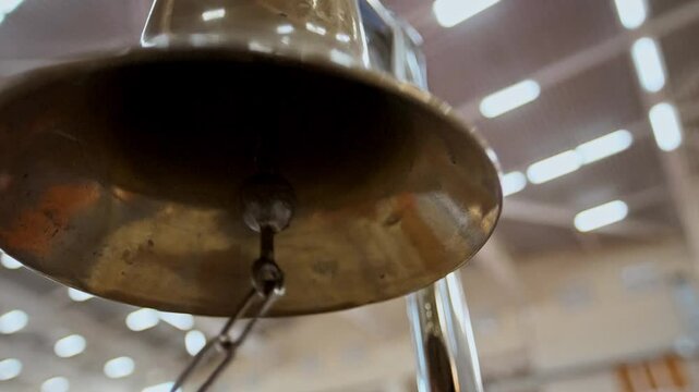 Loud ringing of the gong bell during a martial arts competition in a gymnasium. Close-up 