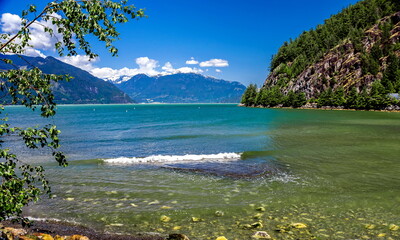 Porteau Cove Provincial Park.  Sunny spring day, sea and mountains, snow-covered mountain range on the horizon,  British Columbia.  Canada. 