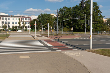 Clear road markings define a safe crossing for pedestrians and cyclists. This regulated intersection is an example of modern urban mobility and traffic safety rules in Warsaw.
