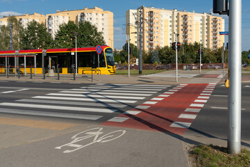 A complete urban ecosystem in Warsaw: a tram, bike path, and crosswalk provide integrated transport for residents of the modern apartment buildings in the background.