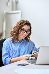 Young happy business woman hr manager coach looking at laptop talking leading hybrid conference online remote video call, virtual work interview meeting or online training working in office, vertical.