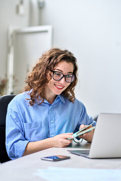 Young happy business woman hr manager coach looking at laptop talking leading hybrid conference online remote video call, virtual work interview meeting or online training working in office, vertical.