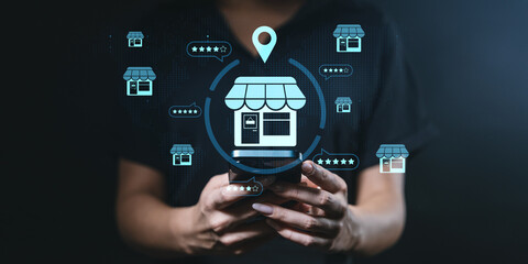 Fototapeta premium Local business search concept with person using smartphone and store icons on screen.