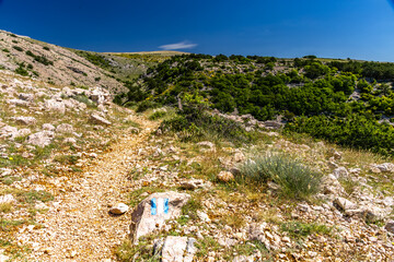 Low walls made of stone built by locals on the trail leading from Baska to Vela Luka beach,
