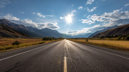 Naklejka premium Open Highway Leading Toward Sunrise in Mountain Landscape