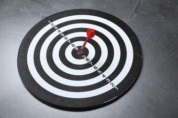 Targeting. Dart board with arrow on gray textured background