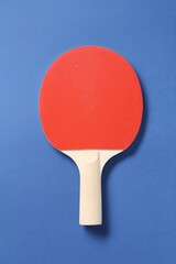 One ping pong racket on blue background, top view