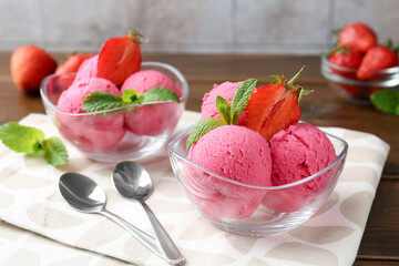 Tasty sorbet with strawberries and mint served on wooden table, closeup