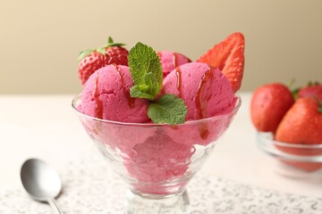 Refreshing sorbet with syrup, strawberries and mint in dessert bowl on white table against beige background, closeup
