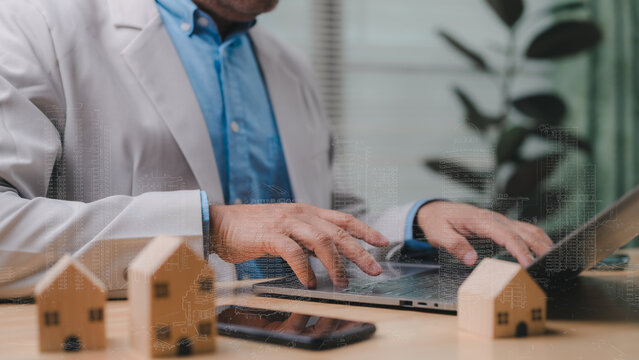 Person On Laptop At Desk, Immersed In Tech driven Real Estate Digital Property And Estate Building Development From Modern Office, With Prominent House Models