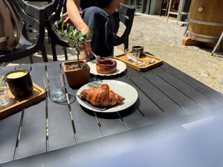 Outdoor breakfast with coffee and pastry on cafe terrace – casual European lifestyle
