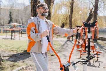 Senior man exercising on outdoor gym equipment in a park