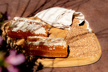 Honey and Honeycomb on a Wooden Board with Floral Arrangement