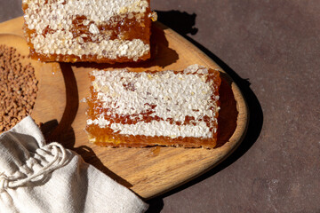 Honey and Honeycomb on a Wooden Board with Floral Arrangement