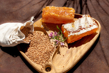 Honey and Honeycomb on a Wooden Board with Floral Arrangement